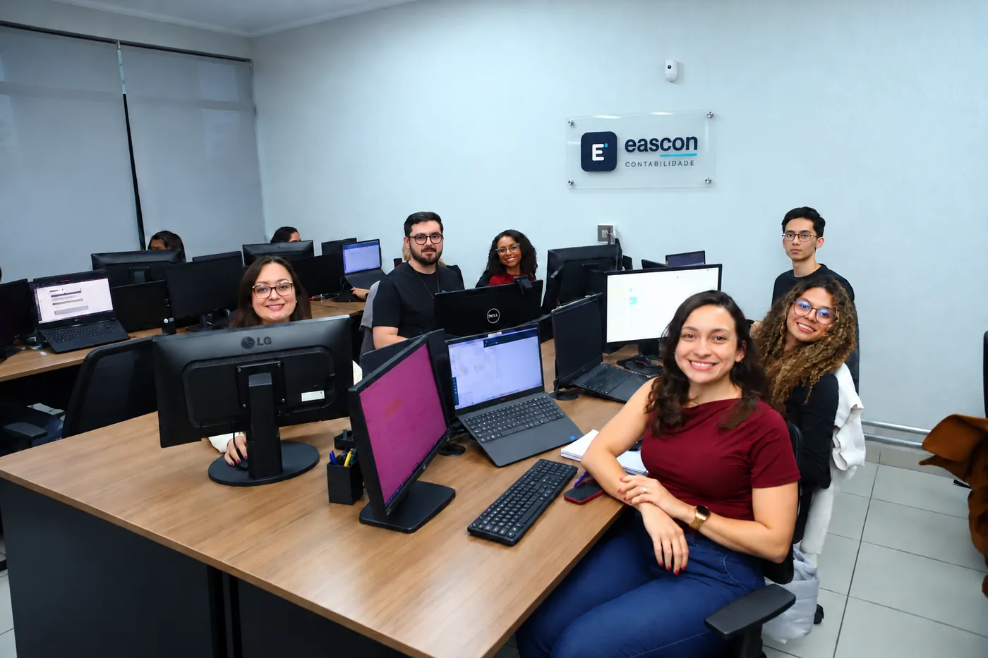 Integrantes da equipe Eascon em seu escritório, sob a marca da empresa